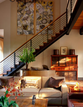 Former artillery shed converted into luxury residence living room with conemporary steel stair, piano and Sally Chandler’s “Sunflower” diptych
