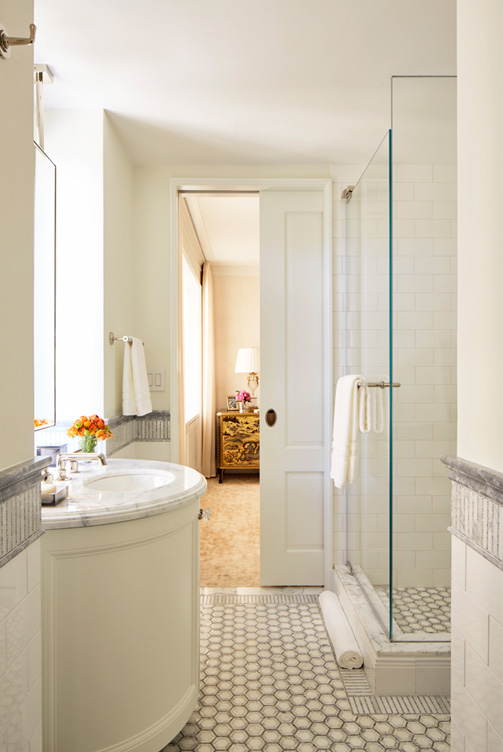 White and grey bathroom, view into bedroom through pocket door