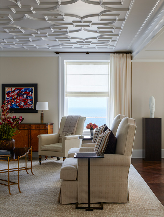 Detail of Chicago penthouse living room in a neutral palette with high-gloss plaster ceiling and view of Lake Michigan