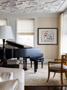 Detail of Chicago penthouse living room in a neutral palette with a piano and artwork by Jean Dubuffet