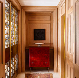Chicago penthouse entry with limestone slab flooring, a cabinet made of leather and American black walnut, and artwork by Louise Nevelson