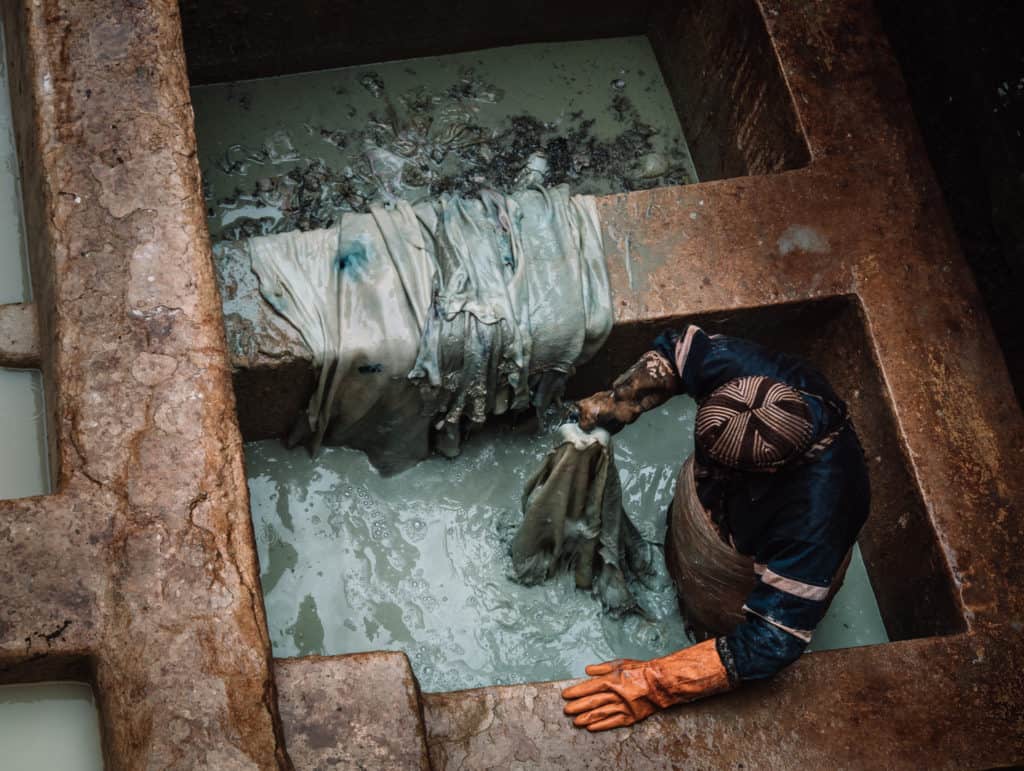 A Fez tannery worker among the vats of colored dyes