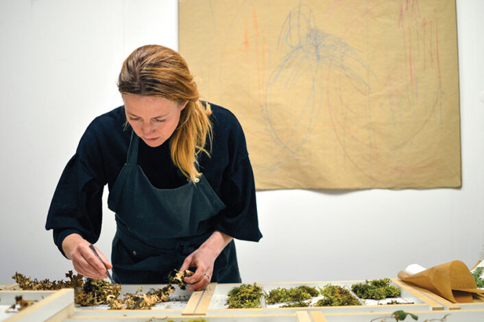 Artist Sasha Sykes at work on one of her artful screens