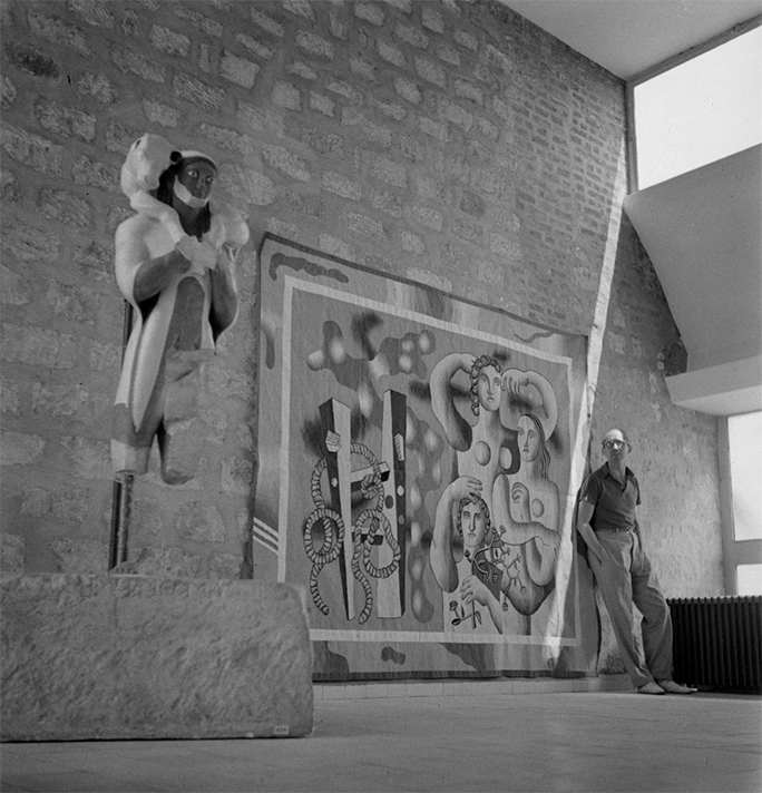 In Paris, Le Corbusier in front of a Fernand Leger tapestry, 