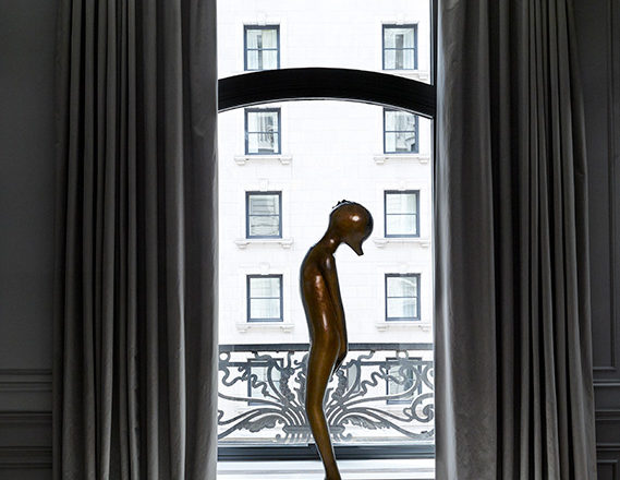 St. Regis, NY owner’s suite primary bedroom detail view with sculpture by Hugo Robus and drapery by Jouffre
