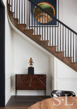 Alcove beneath the staircase in Lincoln Park residence with cabinet by Achille Salvagni and sculpture by Jaume Plensa