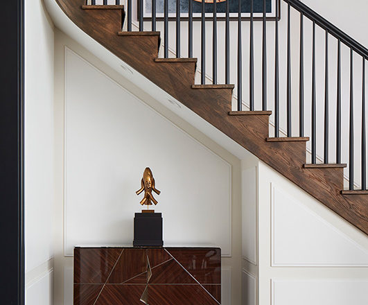 Alcove beneath the staircase in Lincoln Park residence with cabinet by Achille Salvagni and sculpture by Jaume Plensa