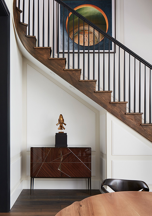 Alcove beneath the staircase in Lincoln Park residence with cabinet by Achille Salvagni and sculpture by Jaume Plensa