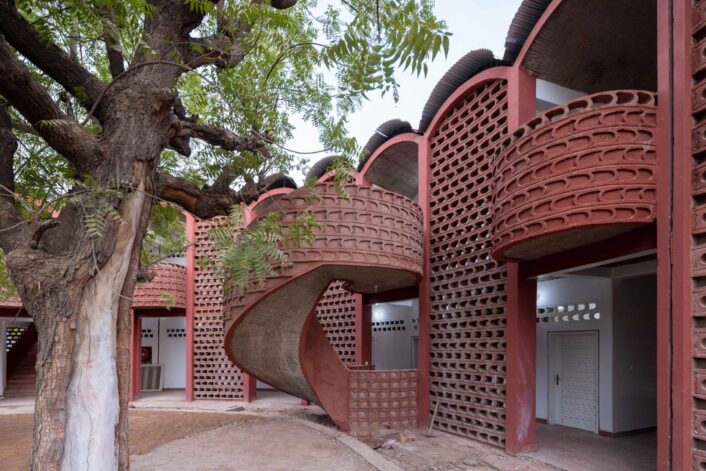 Manuel Herz encloses curvilinear hospital in Senegal with lattice brickwork.