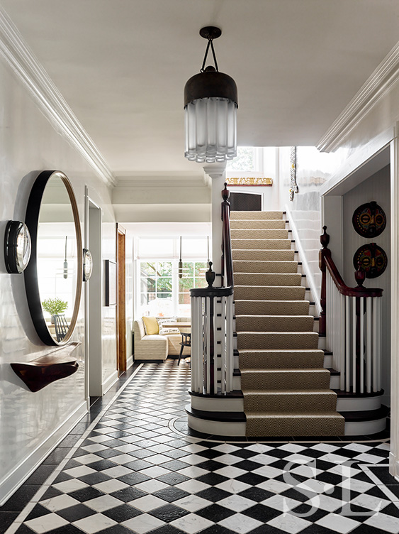 Foyer and stair of Oak Park Landmark Residence with black and white stone floor