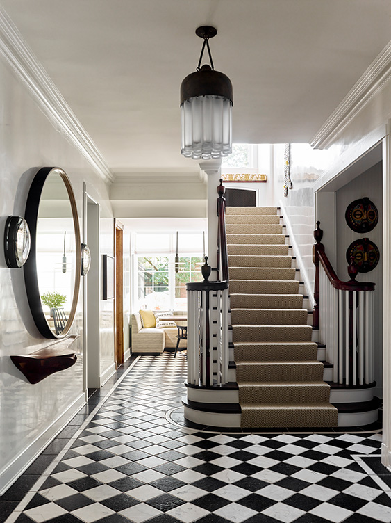Foyer and stair of Oak Park Landmark Residence with black and white stone floor