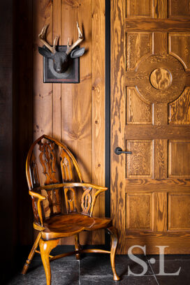 Lakeside residence detail with rustic interior design touches, knotty pine and carved deer head