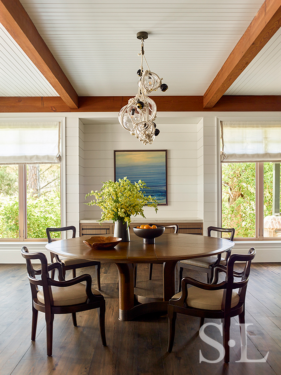 Dining room of luxury vacation residence on Hilton Head Island with shiplap walls and Lindsey Adelman chandelier