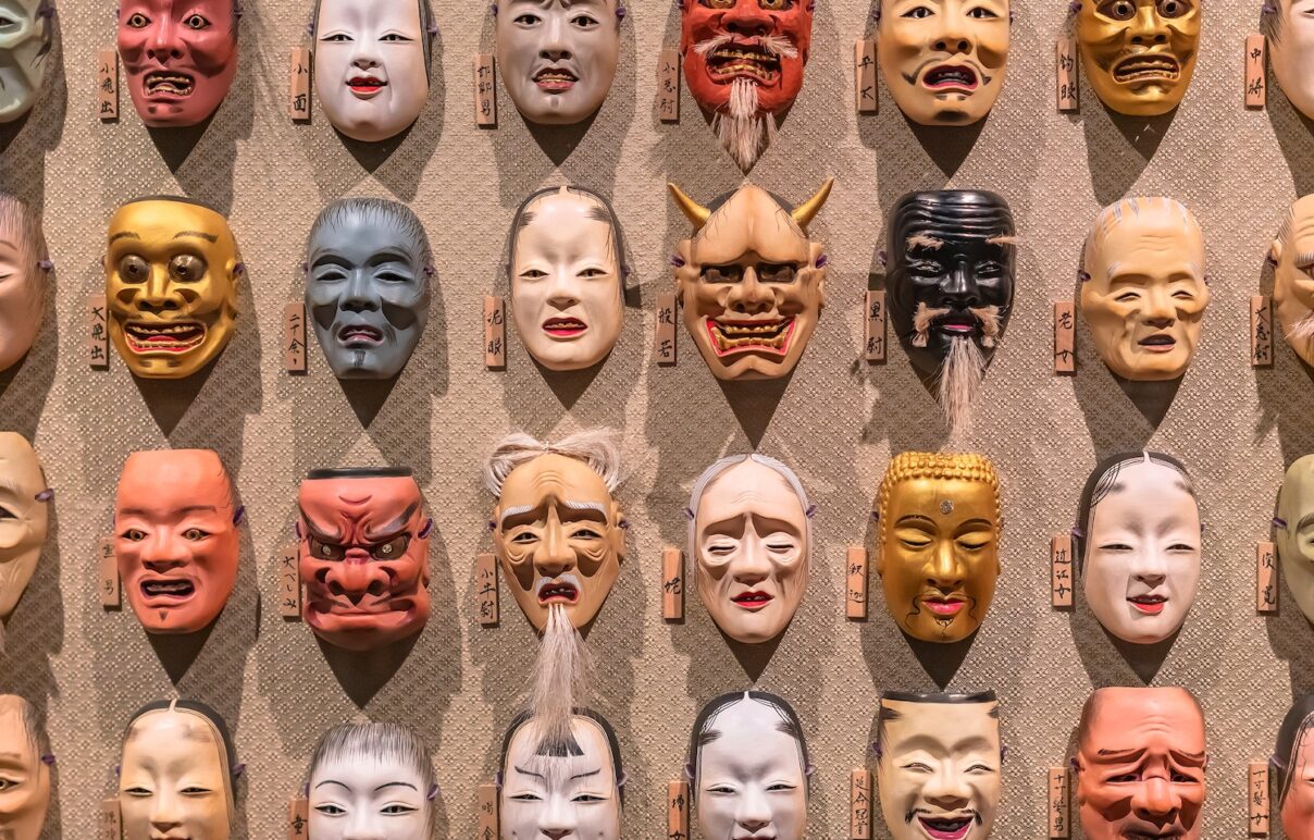 Noh theater masks hanging in a row. The various masks depict different faces... and characters... and are from the collection of Hidetomo Kimura from Art Aquarium.