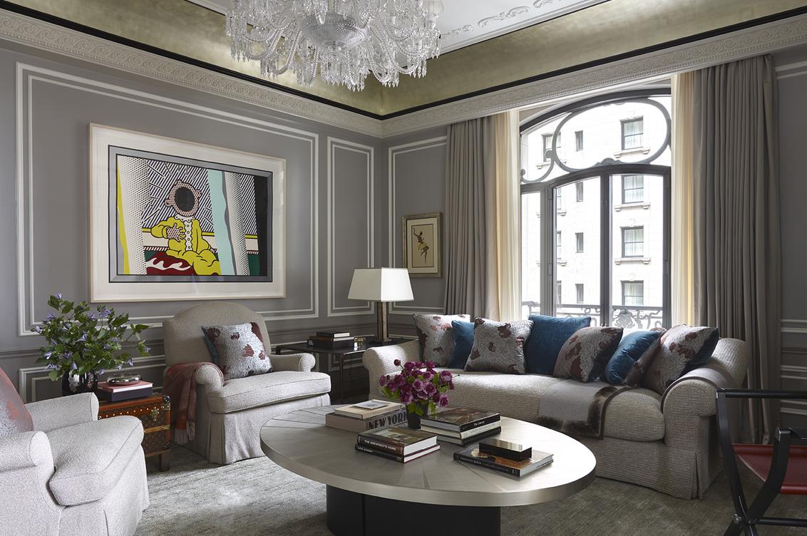 St. Regis, NY owner’s suite living room view featuring Baccarat chandelier and artwork by Roy Lichtenstein